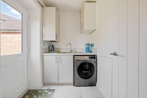 a white kitchen with a washing machine in it at Premium Living Space in Rugby in Rugby