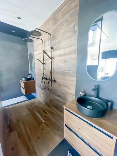 une salle de bain avec un lavabo noir et un miroir dans l'établissement Suite avec jacuzzi et piscine, à Rosières