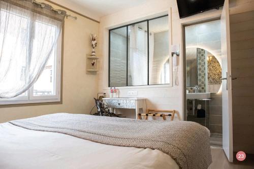 a bedroom with a bed and a sink and a mirror at Hôtel La Casa Pairal in Collioure
