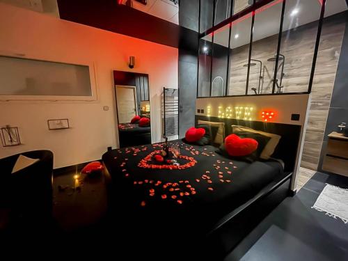 - une chambre avec un lit noir et des oreillers rouges dans l'établissement Suite avec jacuzzi et piscine, à Rosières