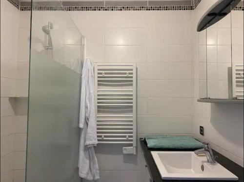 une salle de bain blanche avec un lavabo et une douche dans l'établissement Beau T3 Calme et idéalement situé à Hyères, à Hyères