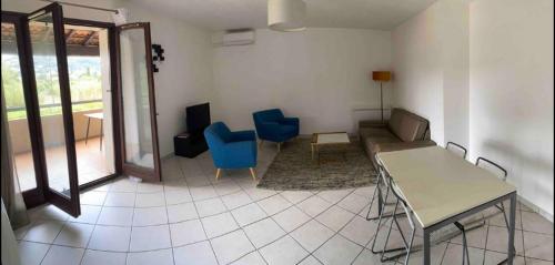 - un salon avec une table et deux chaises bleues dans l'établissement Beau T3 Calme et idéalement situé à Hyères, à Hyères