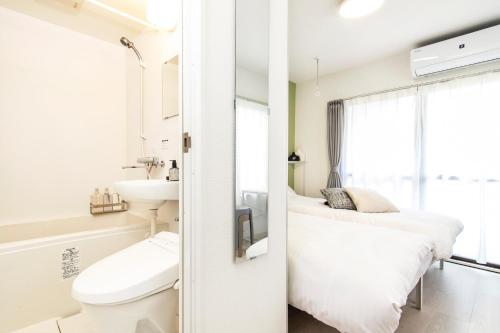 a white bathroom with a bed and a sink at FIKA Shibuya Honmachi 202 in Tokyo