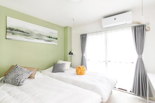 two beds in a room with a window at FIKA Shibuya Honmachi 202 in Tokyo