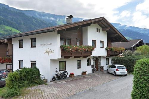 a white house with a motorcycle parked in front of it at Apartment Alpin in Aschau