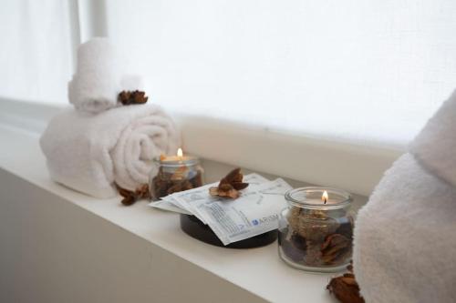 a shelf with candles and a towel and some leaves at CityGem dal design raffinato a Vigonovo in Fontanafredda