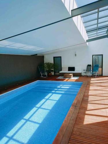 une grande piscine dans une grande pièce avec dans l'établissement Loft avec Piscine Intérieure et Jardin, à Melun