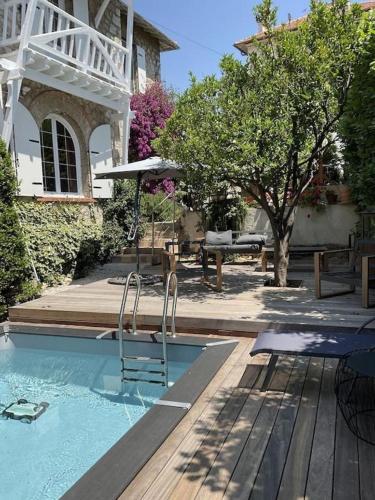 - une piscine avec une chaise et un parasol dans l'établissement Villa 12MN Walk from le palais, à Cannes