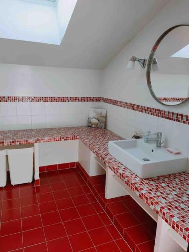 - une salle de bains rouge et blanche avec lavabo et miroir dans l'établissement Loft avec Piscine Intérieure et Jardin, à Melun