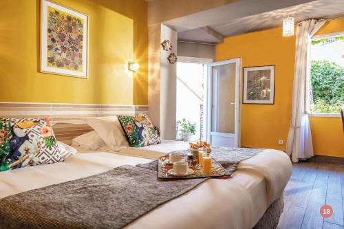 a bedroom with a large bed with a tray on it at Hôtel La Casa Pairal in Collioure