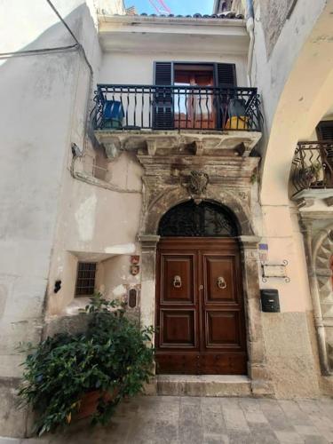 a building with a wooden door and a balcony at casa vacanza pacentro in Pacentro