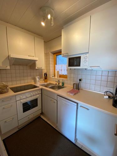 a kitchen with white cabinets and a sink at Tga Muntanela in Savognin