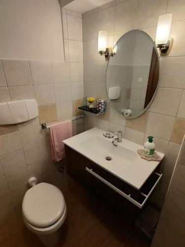 a bathroom with a white toilet and a mirror at casa vacanza pacentro in Pacentro