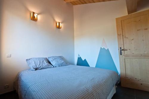 a bedroom with a bed with mountains painted on the wall at Appartement 2 à 4 personnes Chalet Le Bolet in Morzine