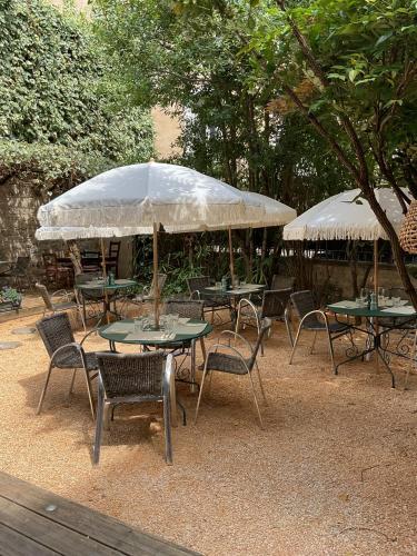 a group of tables and chairs with umbrellas at Chambres de charme MAMIE ANGELE in Saint-Antonin-Noble-Val