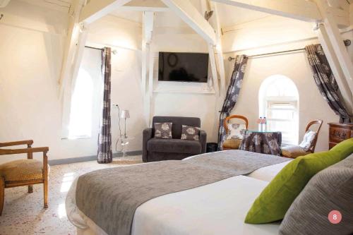 a bedroom with a large bed and chairs in it at Hôtel La Casa Pairal in Collioure