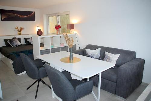 a living room with a couch and a table and chairs at Willkommen in Dagersheim bei Böblingen! Gemütliches 1 Zi Appartement zum Wohlfühlen in einem angenehmen Umfeld! in Böblingen