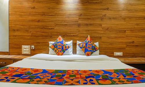 a bed with colorful sheets and pillows on it at Hotel Shades of Royal in Ahmadnagar