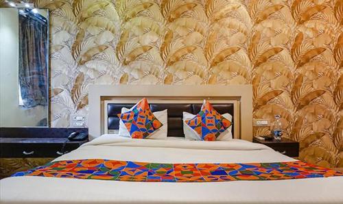 a bedroom with a large bed with colorful pillows at Hotel Shades of Royal in Ahmadnagar