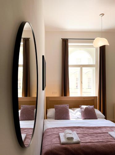 a bedroom with two beds and a mirror at Petrin Tower Residence in Prague