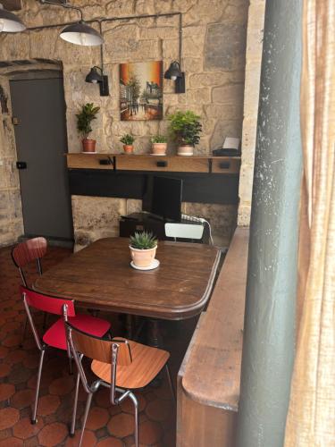 une table et des chaises dans une pièce avec un mur en pierre dans l'établissement Proche Notre Dame de Paris, à Paris