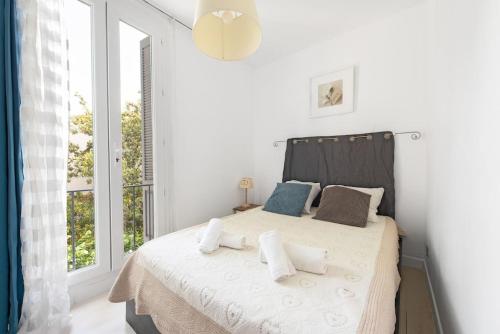 - une chambre blanche dotée d'un lit avec oreillers et d'une fenêtre dans l'établissement Aurore - T1 22, à Carcassone