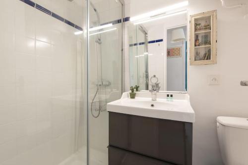 une salle de bain blanche avec un lavabo et une douche dans l'établissement Aurore - T1 22, à Carcassone