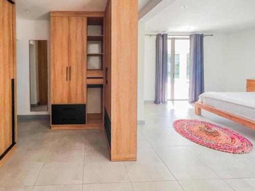 a bedroom with a bed and wooden cabinets and a rug at Happy Place in Arsenal