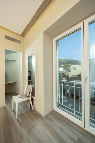 a living room with a large window and a chair at Five by Capri 5 Senses in Anacapri