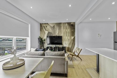 a living room with a couch and a tv at Renovated 2-Bedroom Haven by Jean Talon Market in Montréal