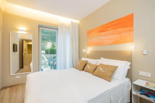a bedroom with a white bed and a mirror at Five by Capri 5 Senses in Anacapri