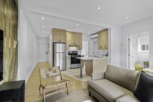 a living room with a couch and a kitchen at Renovated 2-Bedroom Haven by Jean Talon Market in Montréal