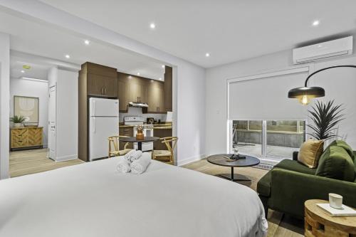 a bedroom with a white bed and a living room at Stylish Open-Space Studio by Jean Talon Market in Montréal