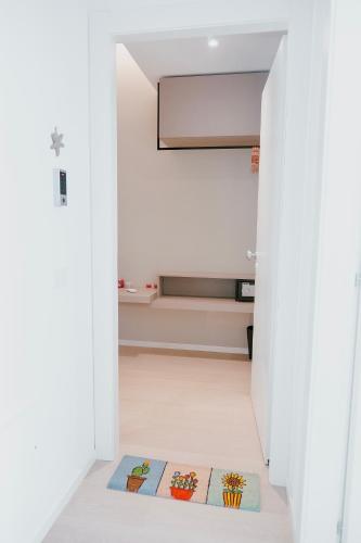 a white hallway with a rug on the floor at 18zero2 luxury rooms in Bari
