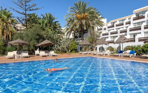 a person swimming in a swimming pool at a hotel at Marhaba Salem - Family Only in Sousse