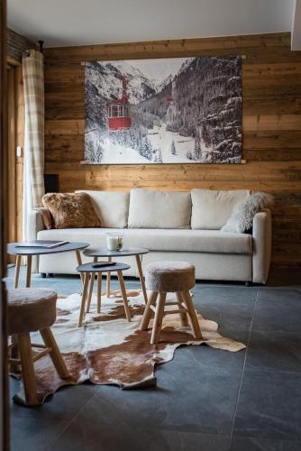 un salon avec un canapé, une table et des chaises dans l'établissement Appartement neuf avec une grande terrasse au cœur du village - 6 personnes, à Saint-Sorlin-dʼArves