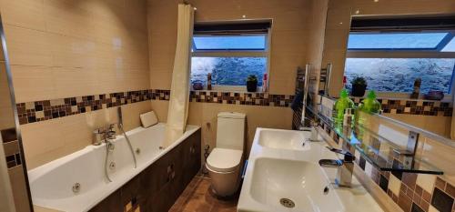 a bathroom with two sinks and a tub and a toilet at 6 Bedroom Spacious villa, Free Parking in Byfleet