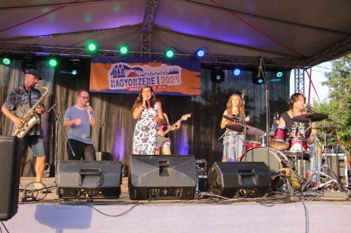 a group of people on a stage playing music at Vadrózsa Apartman Tisza-Tó Poroszló in Poroszló