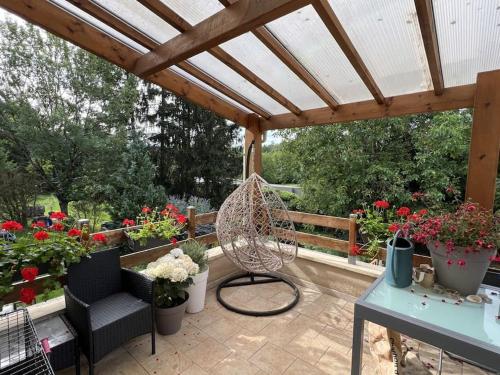 d'une terrasse avec une serre fleurie et un ventilateur. dans l'établissement Maison de Village, à Sainte-Marie-sur-Ouche