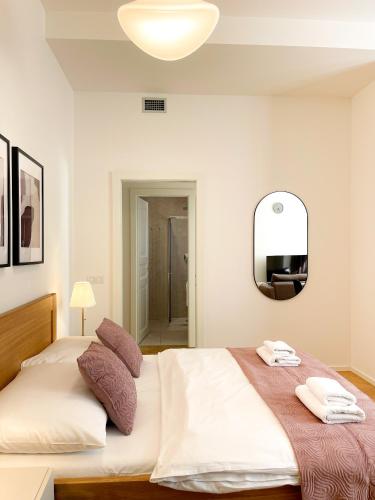 a bedroom with a large bed and a mirror at Petrin Tower Residence in Prague