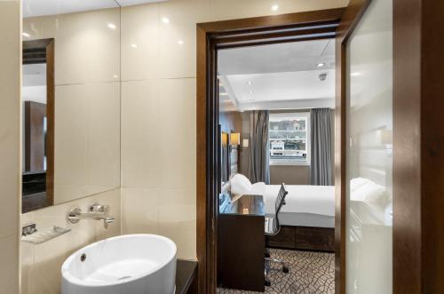 a bathroom with a sink and a mirror at LHA Paddington Hostel in London