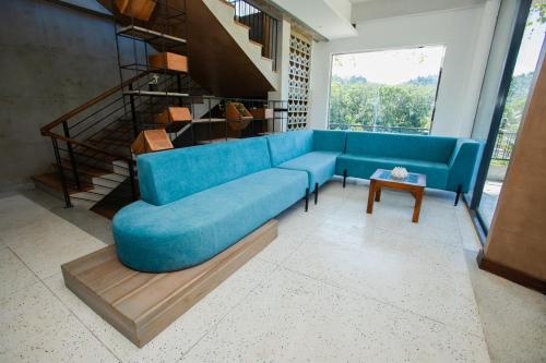 a blue couch in a living room with a staircase at Sueen Nature Resort in Pelenda