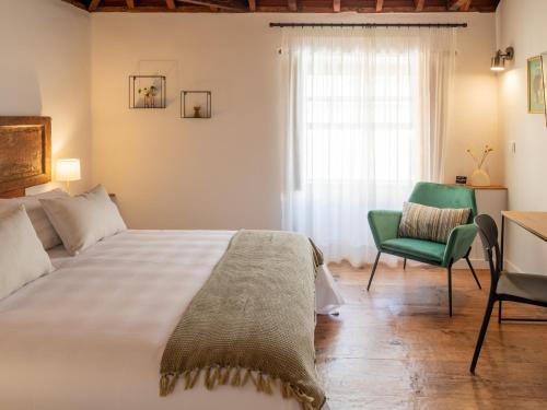 a bedroom with a bed and a chair and a window at Laguna Cool Living in La Laguna