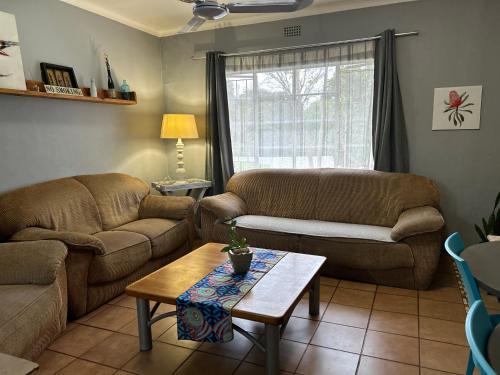 a living room with two couches and a coffee table at Sabie Self Catering Apartments in Sabie