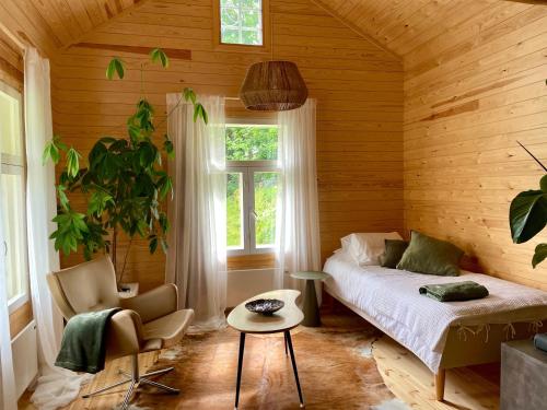 a bedroom with a bed and a chair and a window at Torppa, puusauna ja ilmastointi in Lahti
