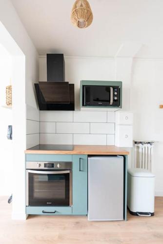 Il comprend une cuisine équipée d'une cuisinière bleue et d'un four micro-ondes. dans l'établissement T2 parking gratuit plus 2 balcons, à Aix-les-Bains