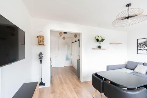 a white living room with a couch and a table at T2 parking gratuit plus 2 balcons in Aix-les-Bains