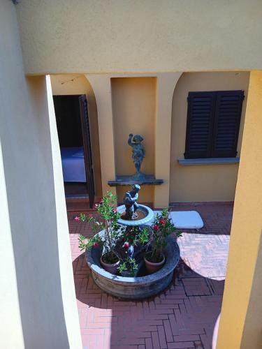 a fountain in the middle of a courtyard with potted plants at Tuscany Villa Gorello. Villa in Toscana. Jacuzzi con tetto in cristallo,piscina in Arezzo