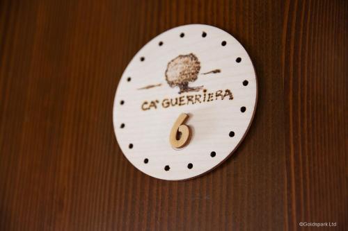 a white clock with the number six on a wooden wall at Agriturismo Ca' Guerriera in Sustinente