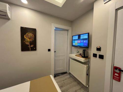 a small room with a door and a tv on the wall at White Palace Haliç in Istanbul